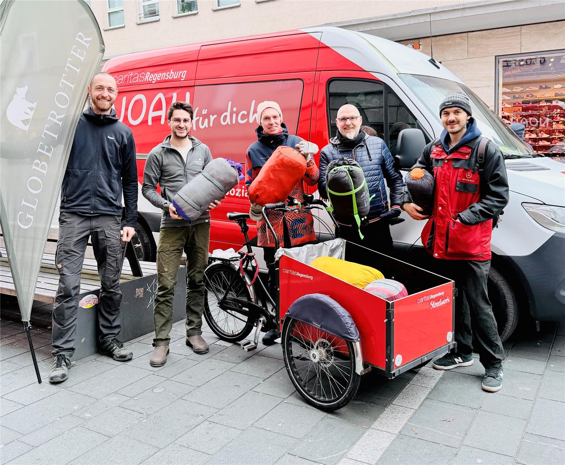 Fünf Personen vor Transportfahrzeug mit der Aufschrift NOAH