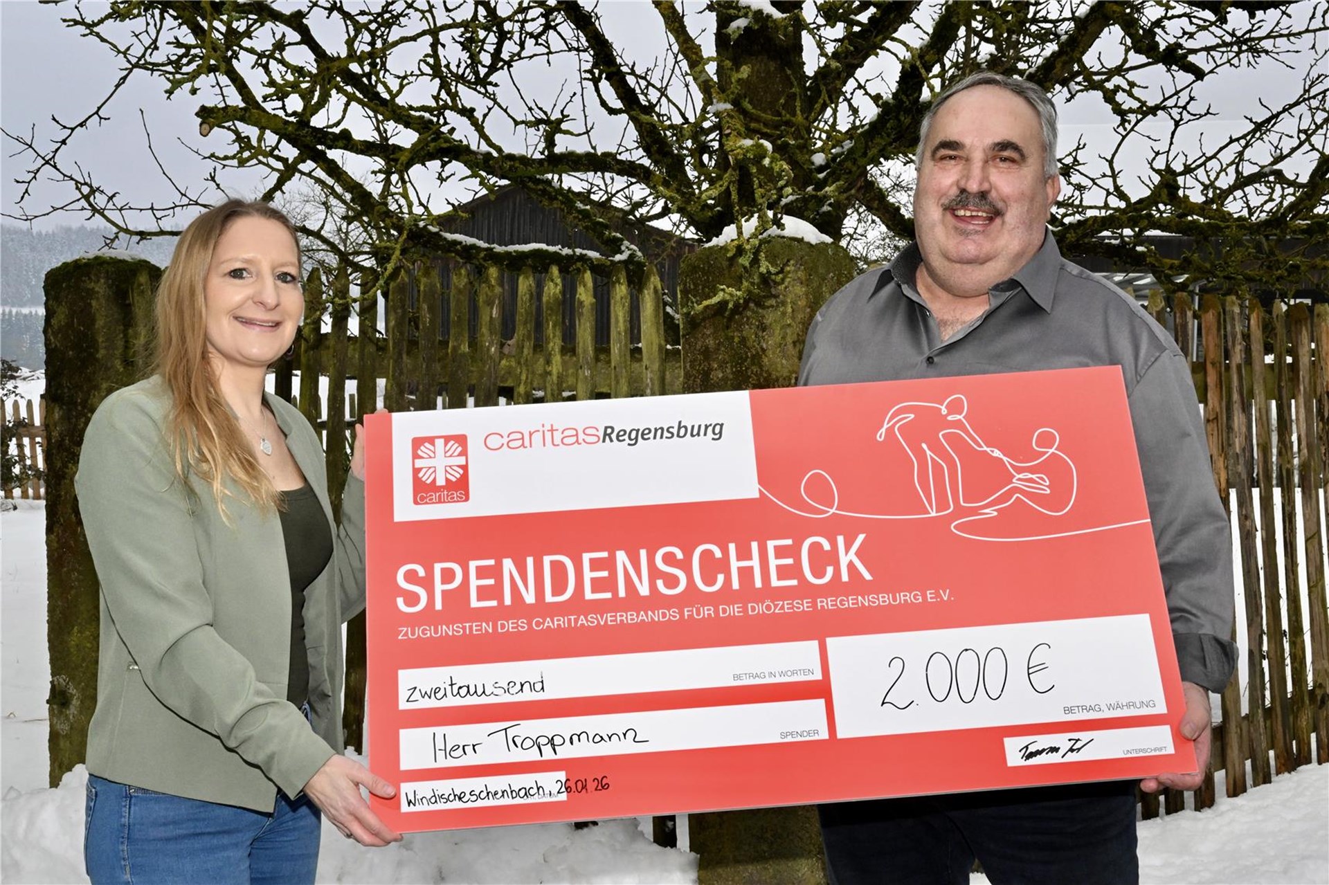 Zwei Personen mit Spendenscheck