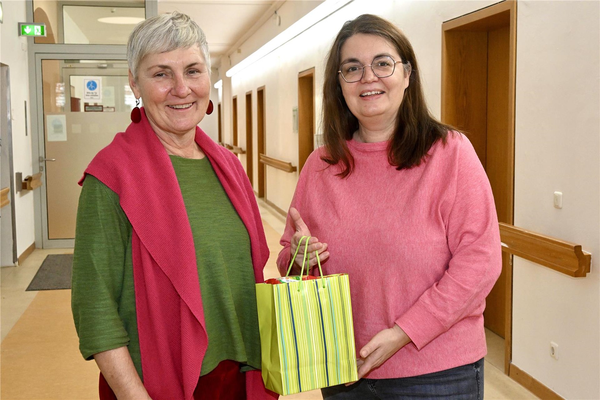 Zwei Personen mit Geschenktüte