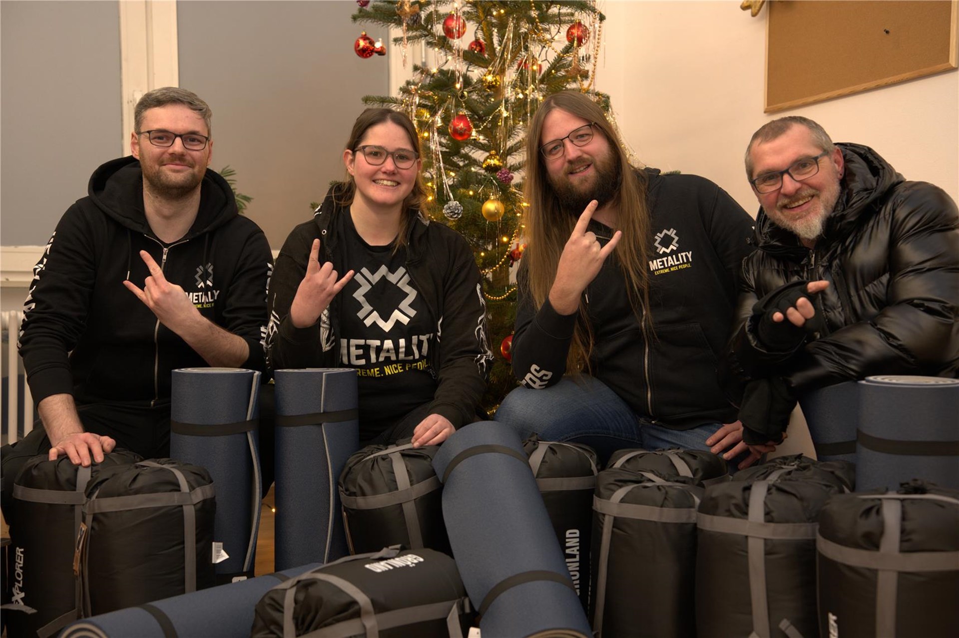 Personen vor Weihnachtsbaum mit Schlafsäcken
